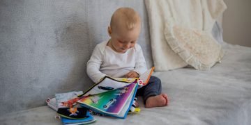 A baby engaged in a home learning activity during homeschooling.