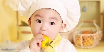 Baby practicing fine motor skills with hands during playtime activities.