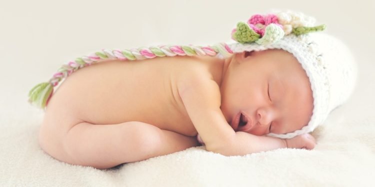A peaceful sleeping baby illustrating the science of infant sleep patterns.