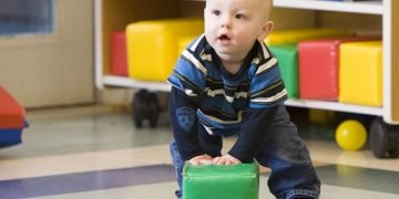 Toddler asserting independence while navigating challenging behaviors during playtime.